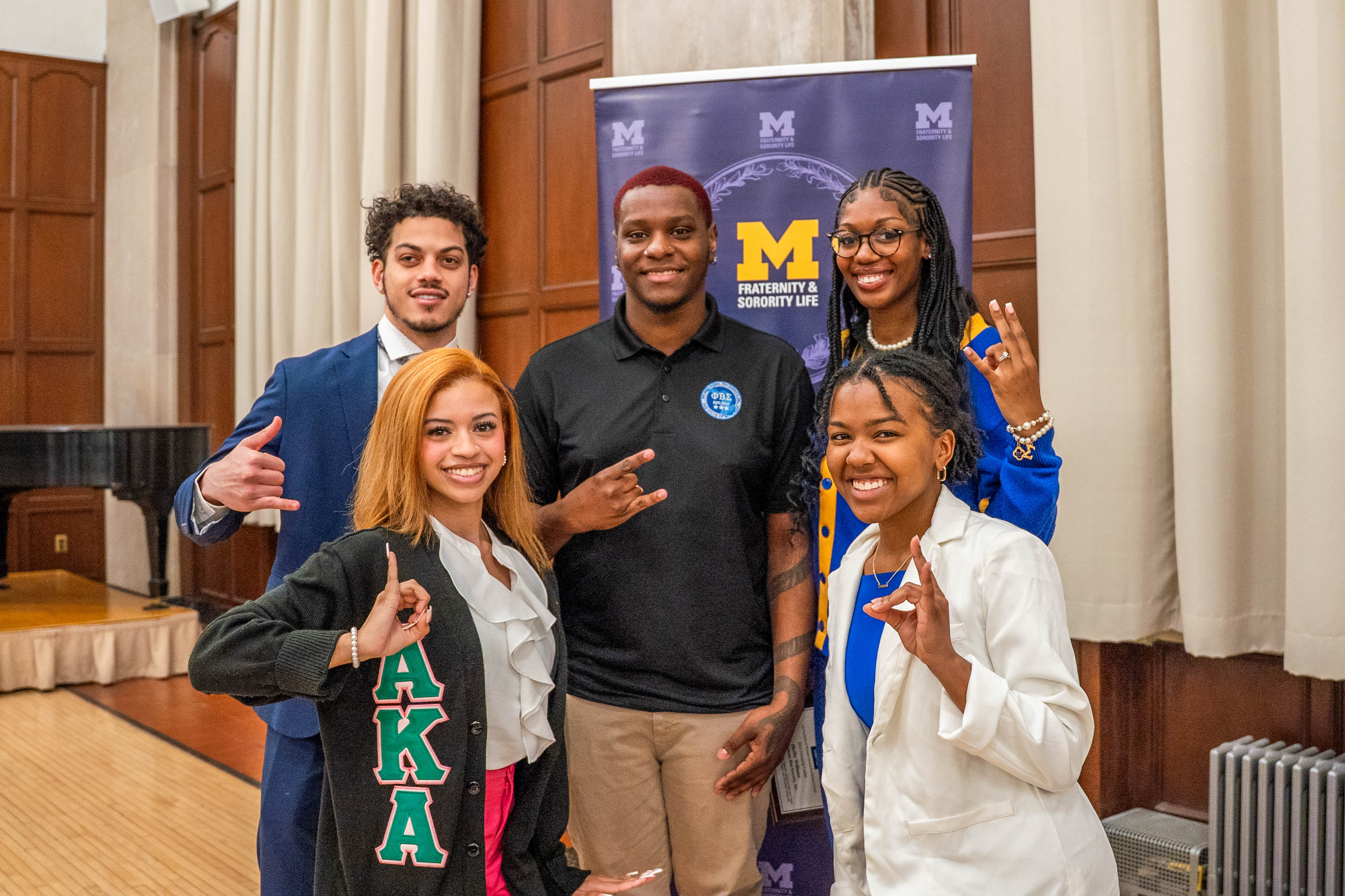 NPHC members at Awards night using organizations hand signs