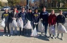 IFC Members holding trash bags cleaning the street on South University